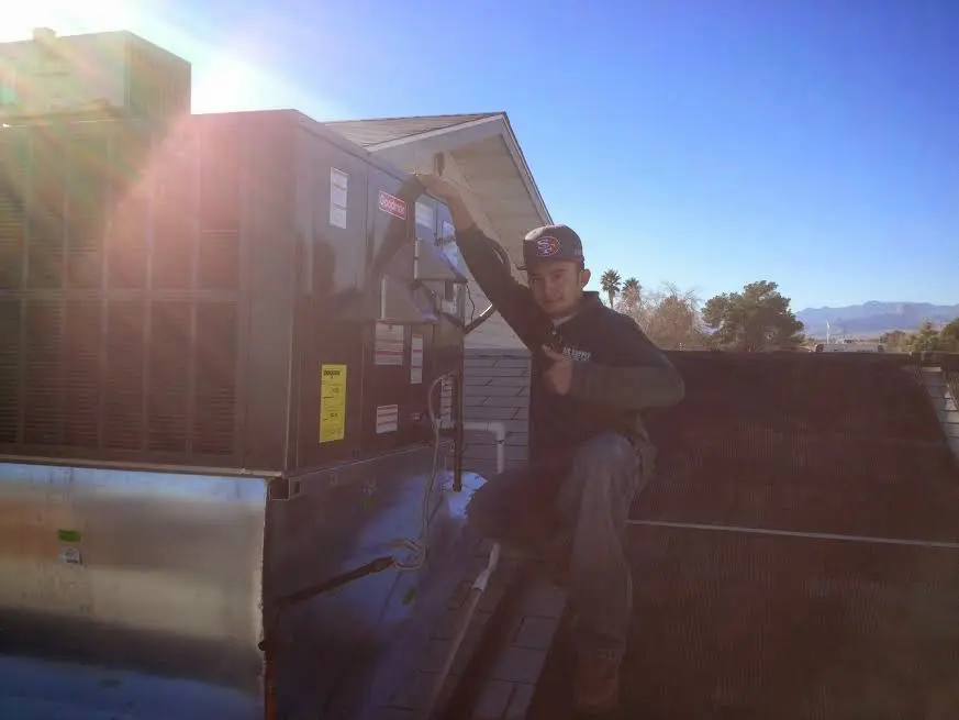 HVAC technician performing AC Tune-Up on a rooftop unit in Greer